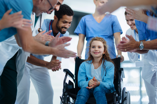 Medical staff clapping to patient who recovered from a serious illness.