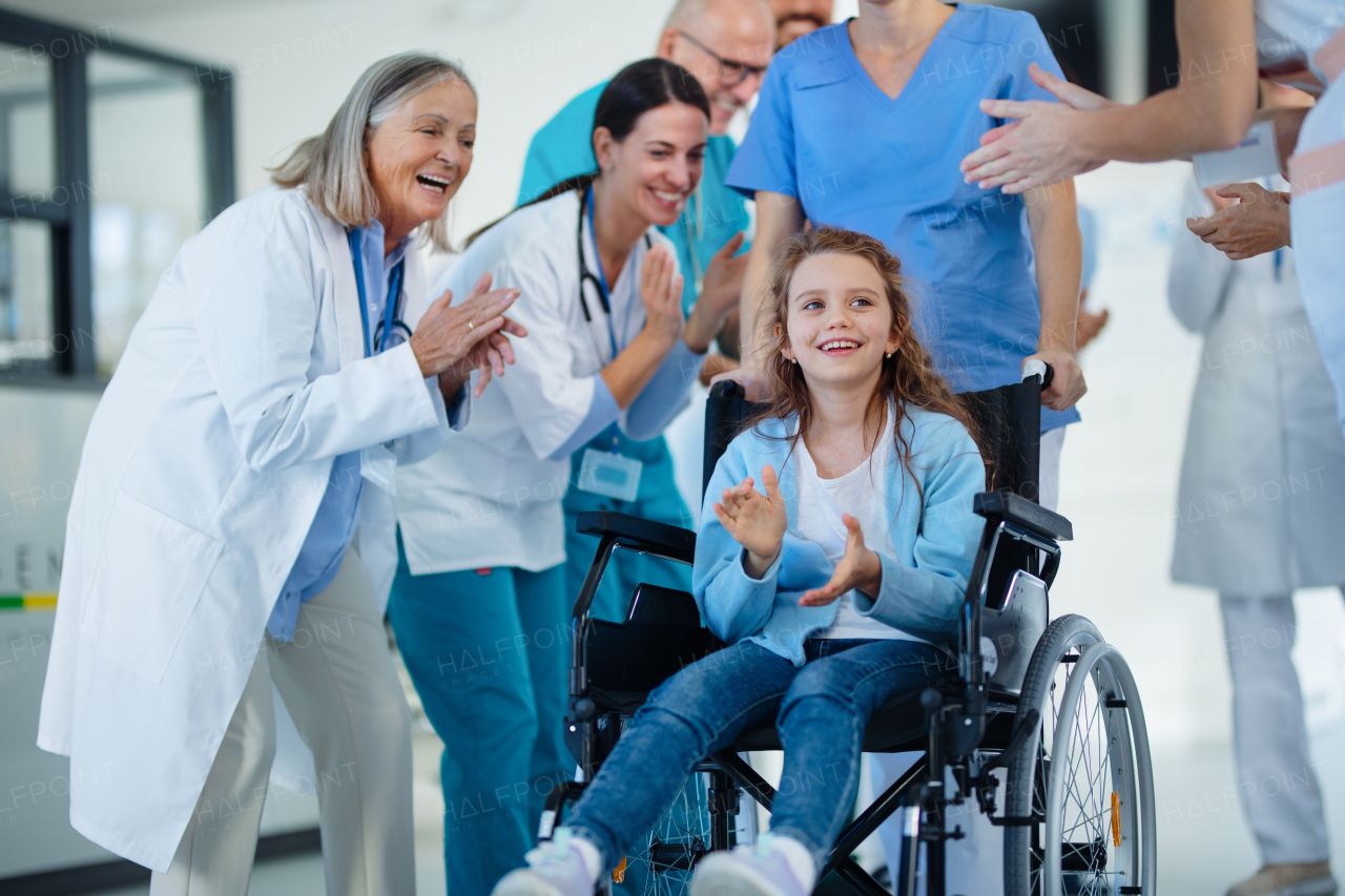 Medical staff clapping to patient who recovered from a serious illness.