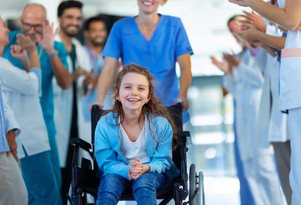 Medical staff clapping to patient who recovered from a serious illness.