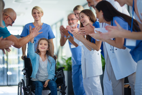 Medical staff clapping to patient who recovered from a serious illness.