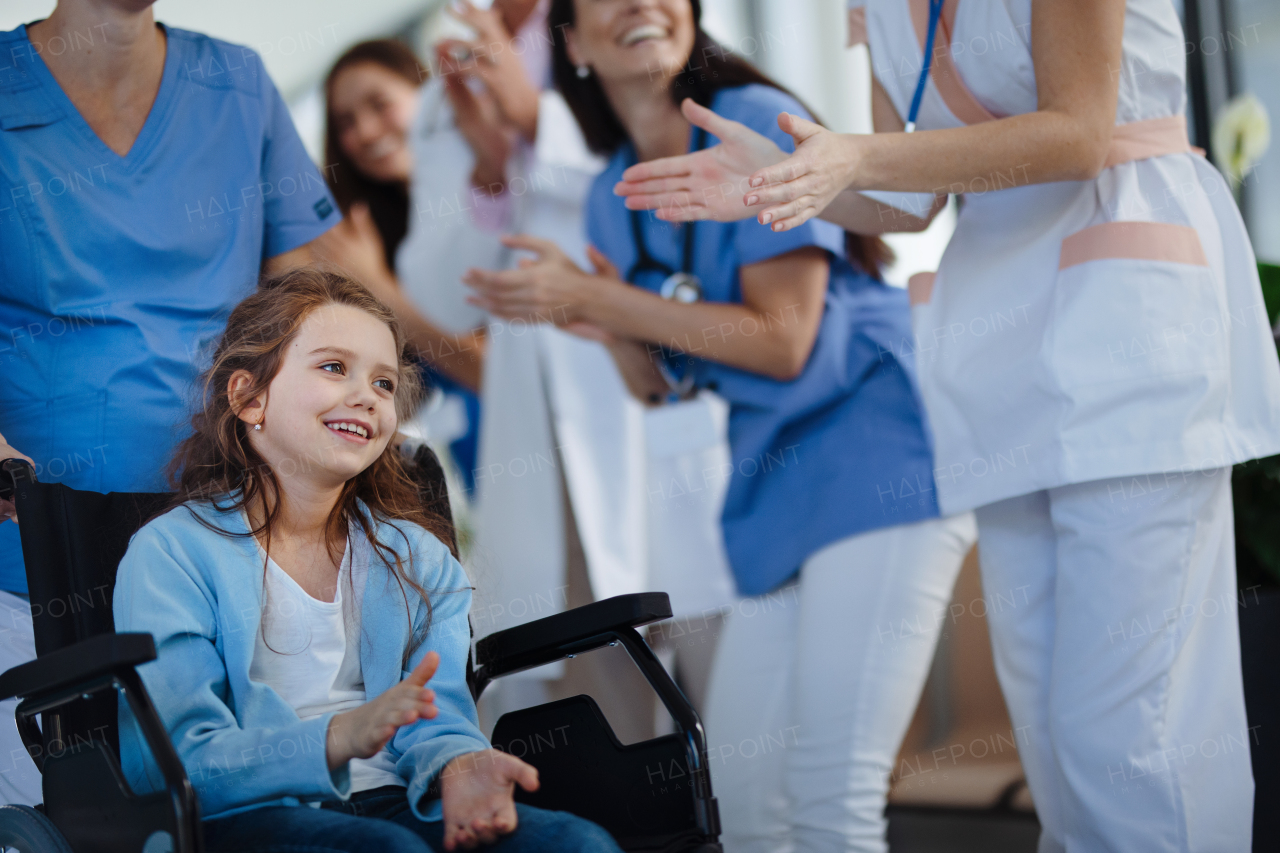 Medical staff clapping to patient who recovered from a serious illness.