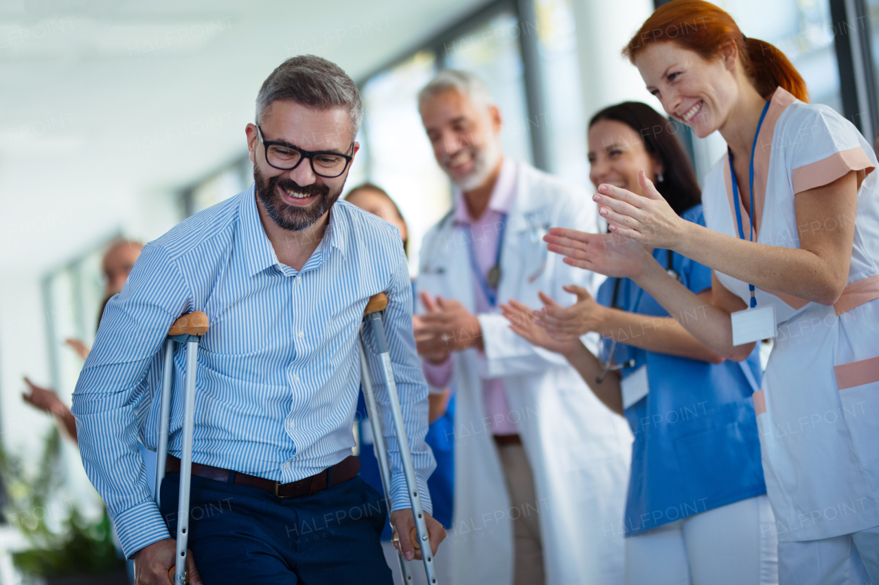 Medical staff clapping to patient who recovered from a serious accident.