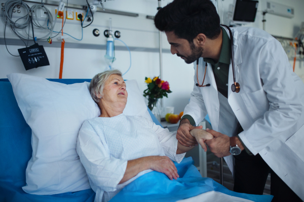 Young doctor checking blood presure to senior patient.