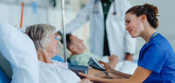 Young nurse measuring blood presure to senior patient.