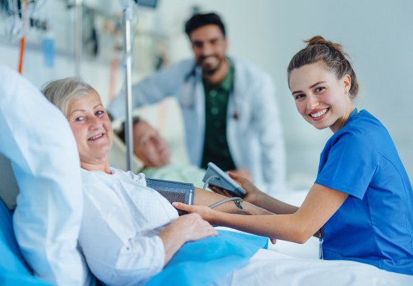 Young nurse measuring blood presure to senior patient.