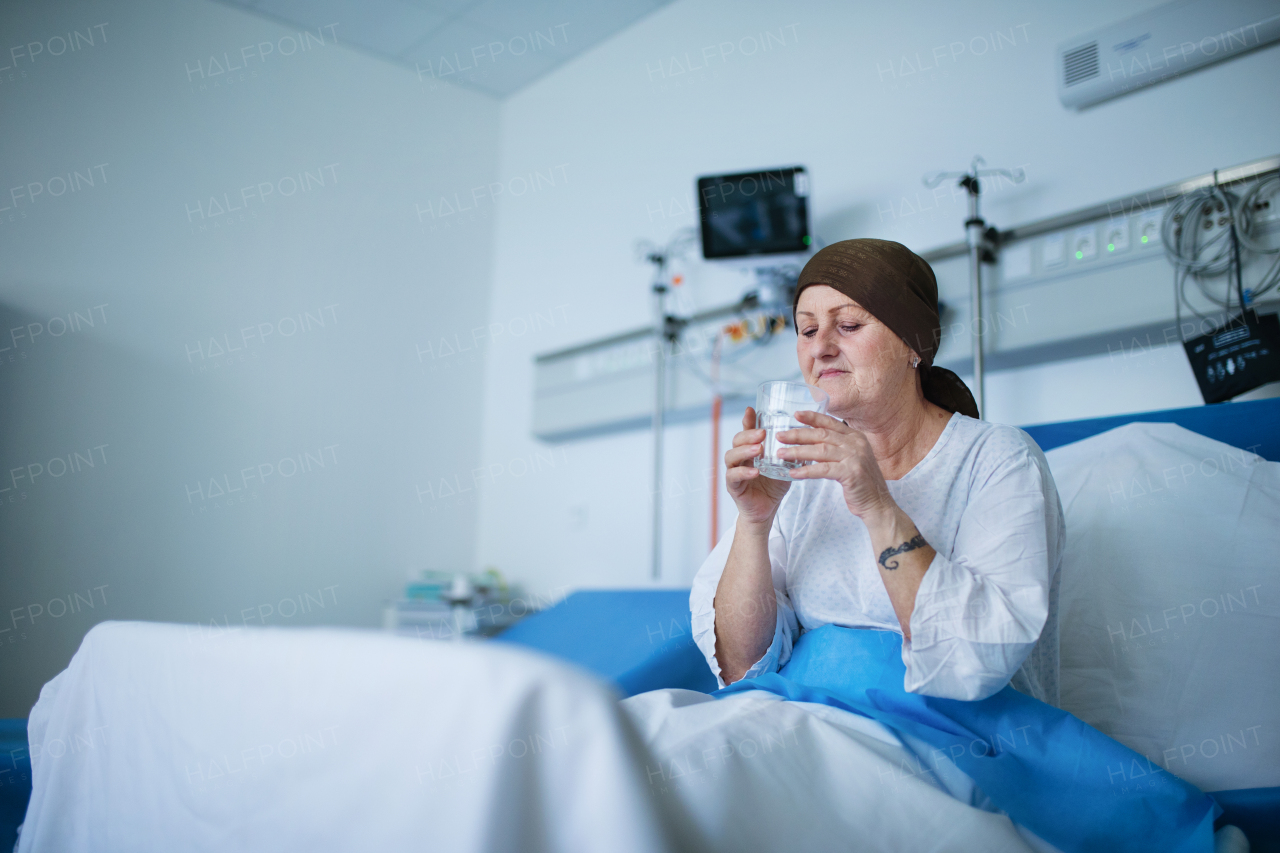 Senior woman sitting in hospital room after the chemotherapy.