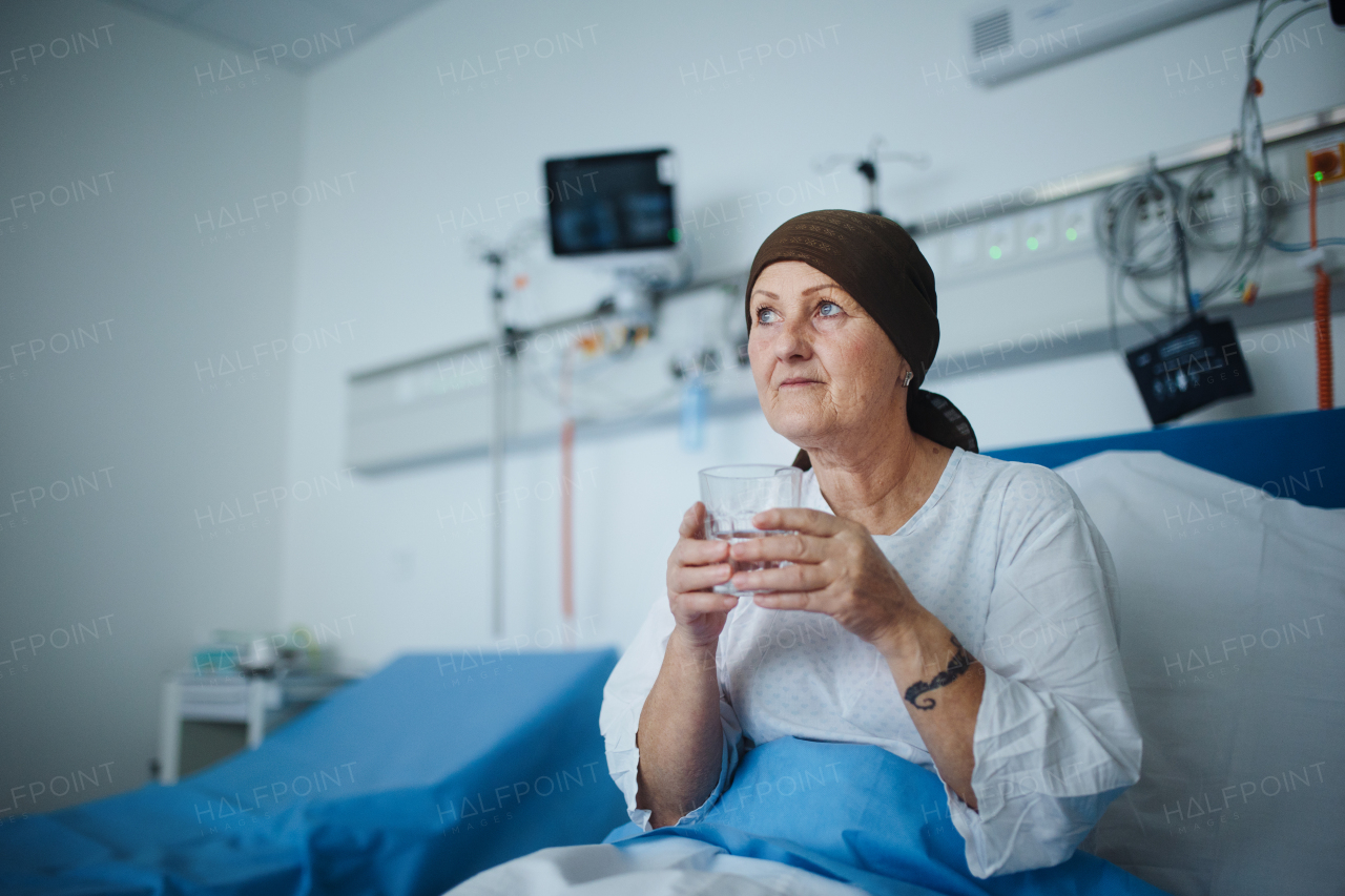 Senior woman sitting in hospital room after the chemotherapy.