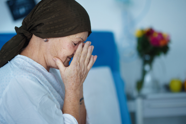 Senior woman sitting in hospital room after the chemotherapy.