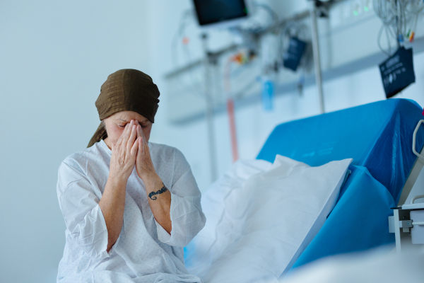 Senior woman sitting in hospital room after the chemotherapy.