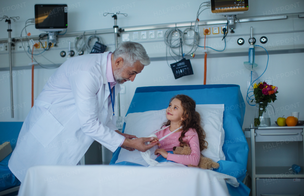 Doctor examining a little girl with broken arm.