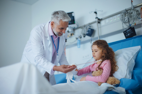 Doctor examining a little girl with broken arm.