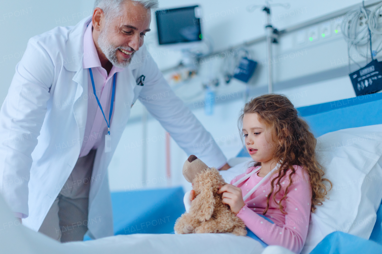 Friendly doctor taking care and playing with little patient.