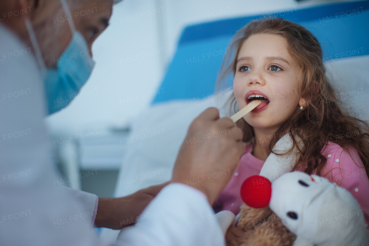 Close-up of examining little girls throat in a hospital.