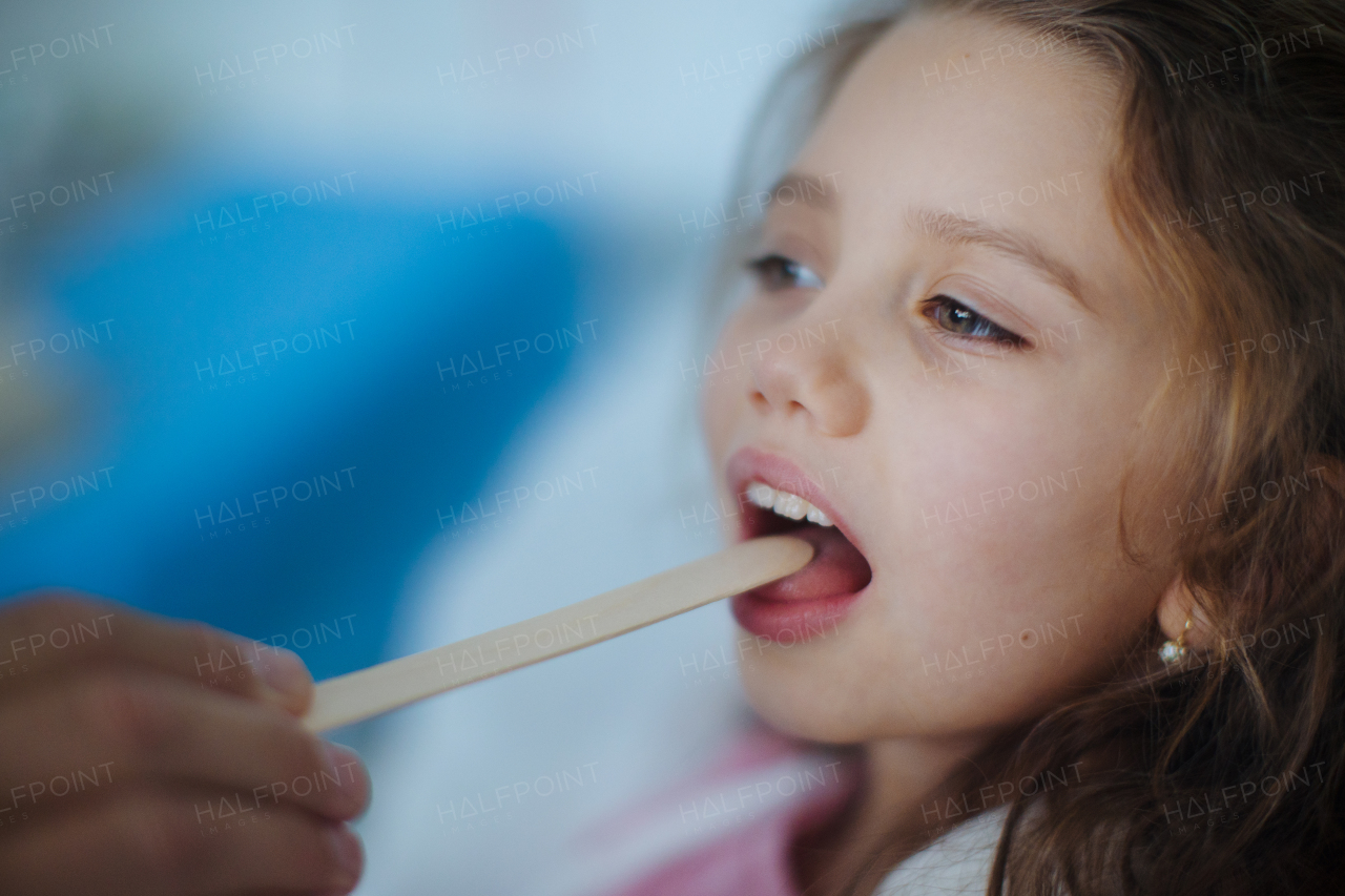 Close-up of examining little girls throat in a hospital.