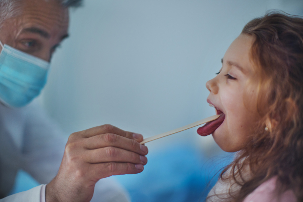 Close-up of examining little girls throat in a hospital.