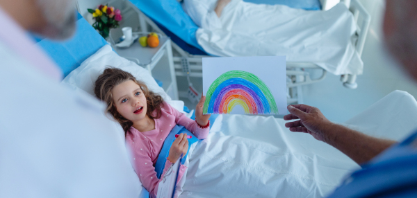 Little girl in a hospital room drew a nice picture of rainbow, concpet of healing and hope.