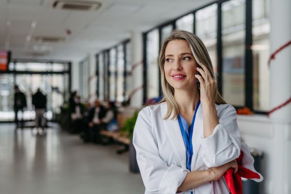 Portrait of beautiful female doctor with christmas hat in hand phone calling. Working in hospital on the Christmas day, Christmas Eve. Female doctor working a Christmas shift and can't be with her family.