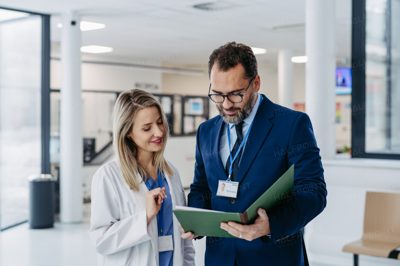 Pharmaceutical sales representative talking with doctor in medical building. Female doctor talking with hospital director, manager in the private clinic.