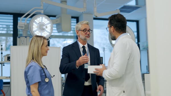 Video of pharmaceutical sales representative standing in doctor office, shaking hands. Hospital director, manager of private medical clinic greeting new doctors. Generous donor, giving donation to hospital. Through door.