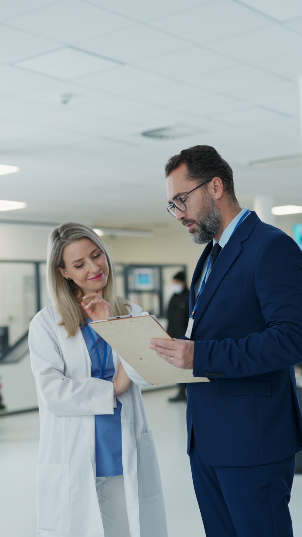 Pharmaceutical sales representative talking with doctor in medical building. Female doctor talking with hospital director, manager in the private clinic.