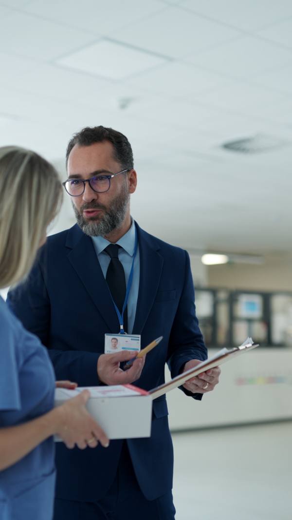 Pharmaceutical sales representative talking with doctor in medical building. Female doctor talking with hospital director, manager in the private clinic.