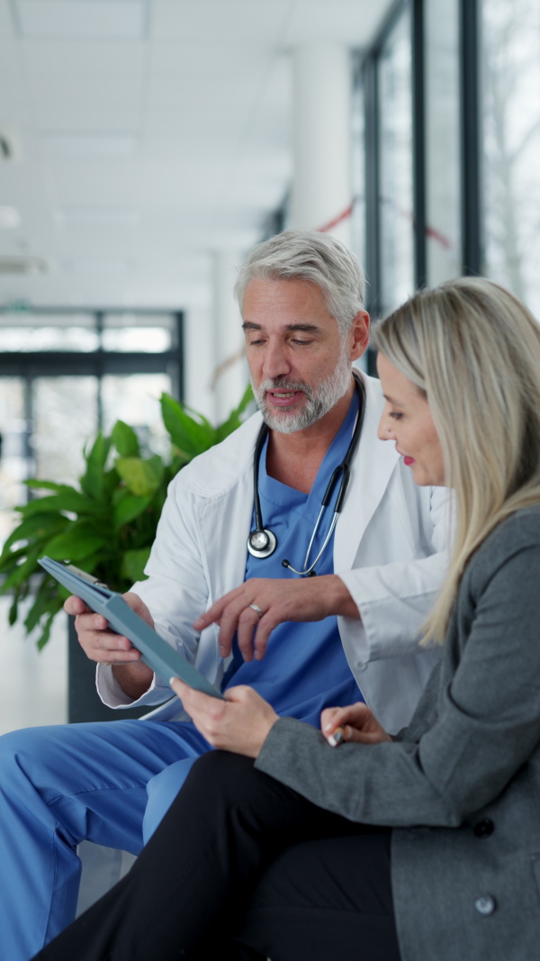 Pharmaceutical sales representative talking with doctor in medical building. Female medical rep presenting new medication. Female hospital director with medical director.