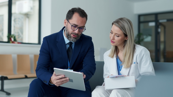 Pharmaceutical sales representative talking with doctor in medical building. Female doctor talking with hospital director, manager in the private clinic.