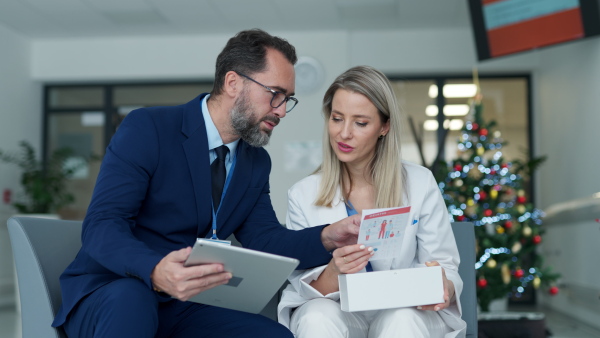 Pharmaceutical sales representative talking with doctor in medical building. Female doctor talking with hospital director, manager in the private clinic.