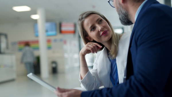 Pharmaceutical sales representative talking with doctor in medical building. Female doctor talking with hospital director, manager in the private clinic.