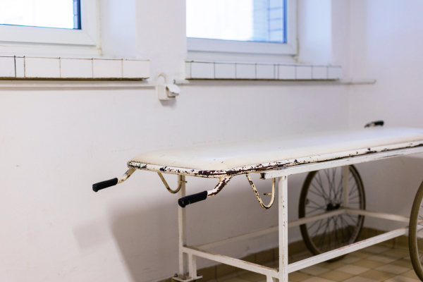 Close up of hospital stretcher with wheels. Outdated vintage hospital gurney in the hospital corridor.