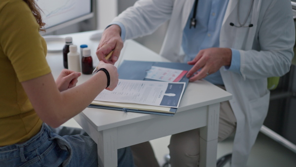 Close up of tennage girl visiting pediatrician doctor, discussing test results. Concept of preventive health care for adolescents.