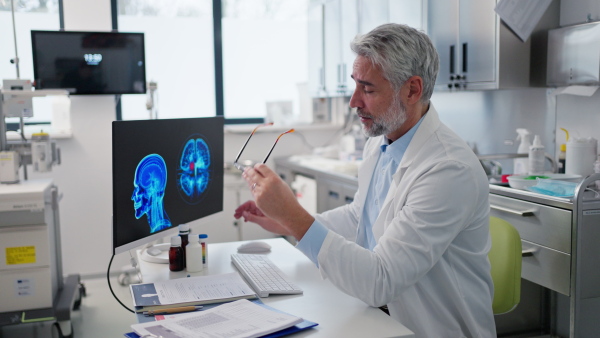 Video of sad doctor looking at an MRI scan, patient's bad test results, feeling helpless. Recurrence of the disease