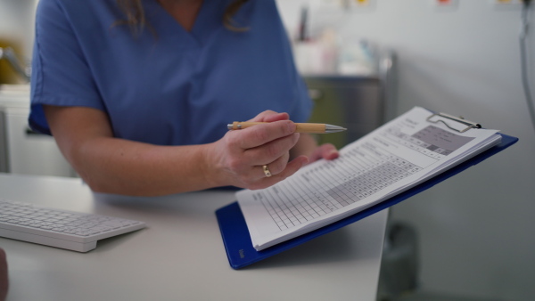 Close up of female doctor consulting with overweight patient, discussing test result and x-ray scans in doctor office. Concept of health risks of overwight and obesity.