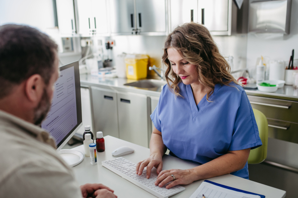 Female doctor consulting with overweight patient, discussing test result and x-ray scans in doctor office. Concept of health risks of overwight and obesity.