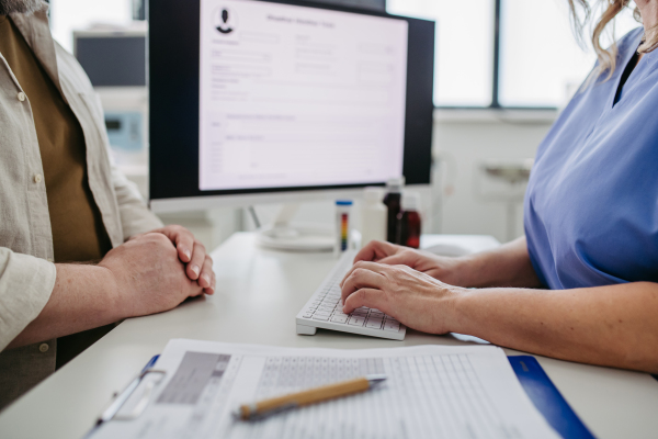 Female doctor consulting with overweight patient, discussing test result in doctor office. Concept of health risks of overwight and obesity.