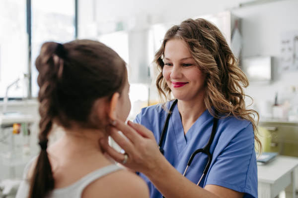 Female doctor examining lymp nodes on neck of the young girl. Palpation of lymph nodes. Concept of preventive health care for childre