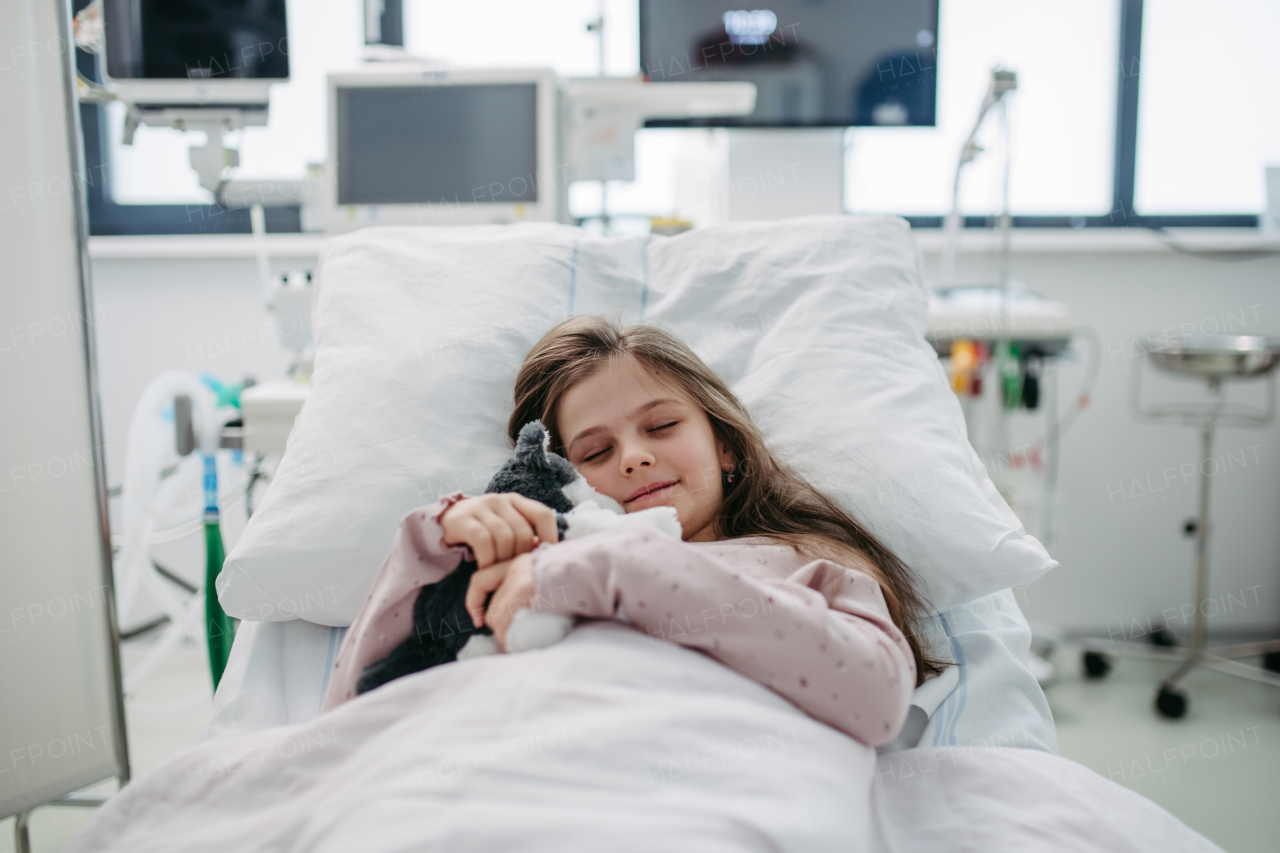 Little girl patient lying in hospital bed. Children in intensive care unit in hospital sleeping. Banner with copy space.