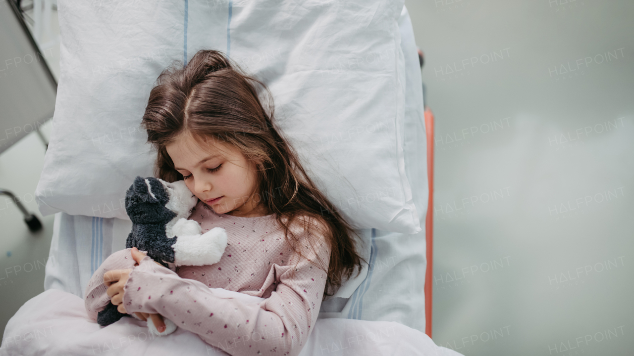 Little girl patient lying in hospital bed. Children in intensive care unit in hospital sleeping. Banner with copy space.