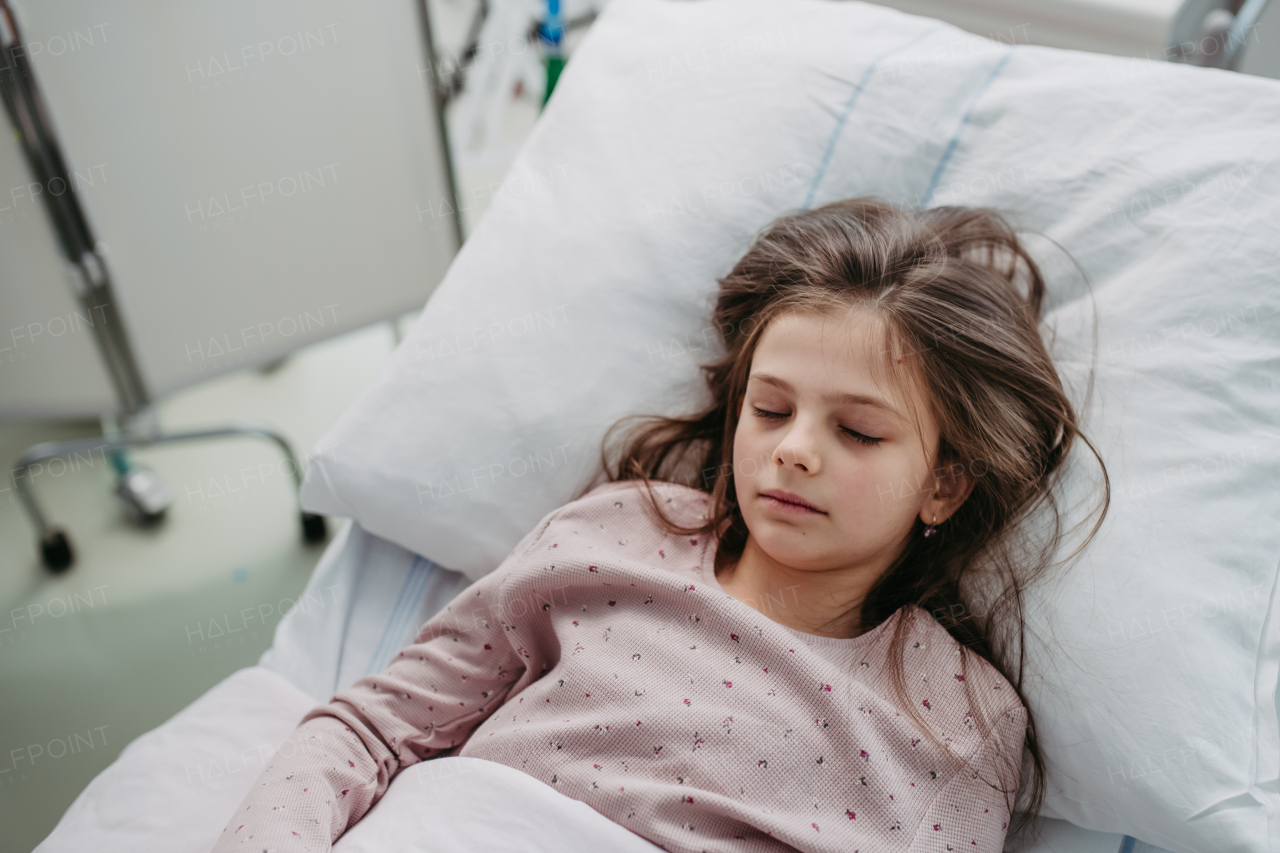 Little girl patient lying in hospital bed. Children in intensive care unit in hospital sleeping. Banner with copy space.