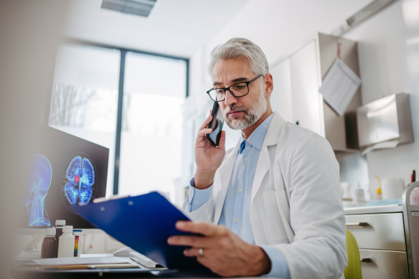 Portrait of sad doctor looking at an MRI scan, patient's bad test results, feeling helpless. Recurrence of the disease