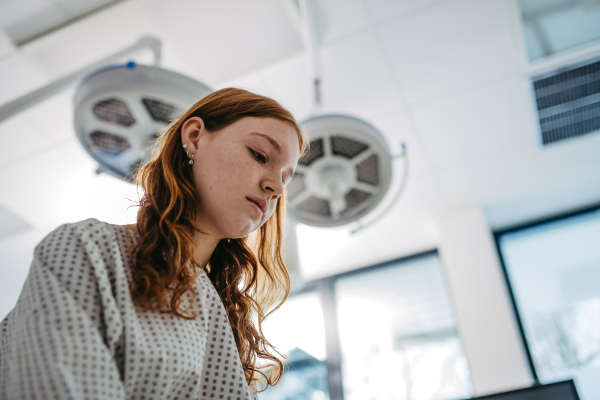 Close up of scared teenage patient, waitng for test results. Anxiety, worry and loneliness of teenager in hospital. Emotional support for ill young girl.