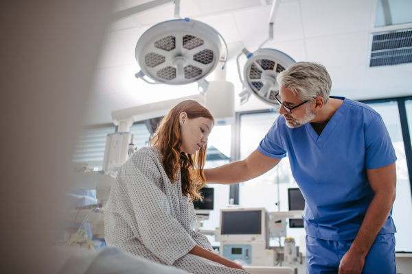 Supportive doctor talking with worried teenage patient. Compassionate physician supporting stressed girl, delivering bed news. Emotional support.