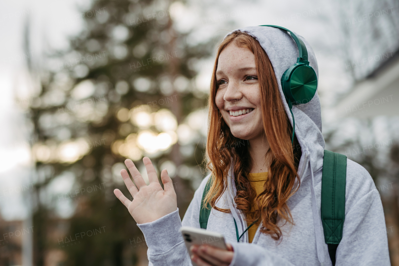 Portrait of teenage girl looking at her smartphone, feeling sad, anxious, alone. Cyberbullying, girl is harassed, threated online.