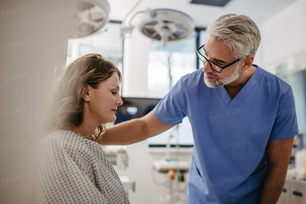 Supportive doctor soothing a worried female patient, discussing test result in emergency room. Compassionate physician supporting stressed patient.