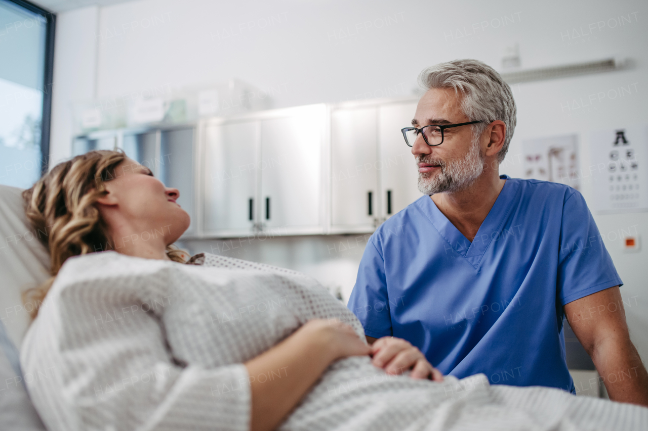 Doctor talking with worried female patient, emotional support before surgery. Friendly male doctor reassuring the patient.