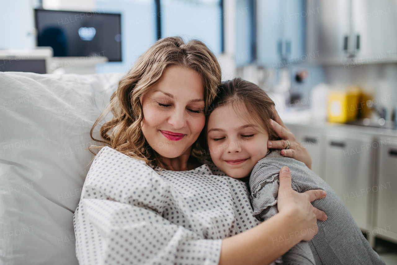 Daughter visiting mother in hospital after successful surgery, hugging her. Emotional support from family for patients in hospital.