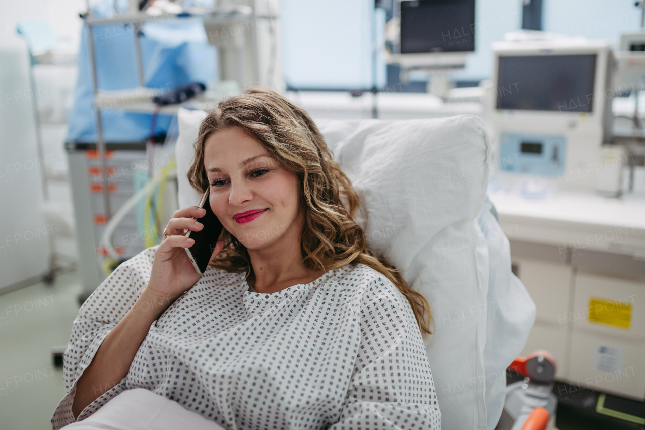 Happy woman phone calling from hospital room after successful surgery. Emotional support from family for patients in hospital.