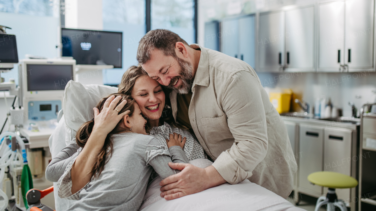 Father and daughter visiting mother in hospital after successful surgery. Emotional support from family for patients in hospital.