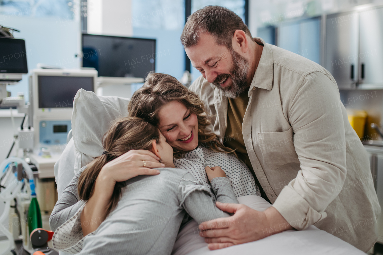 Father and daughter visiting mother in hospital after successful surgery. Emotional support from family for patients in hospital.