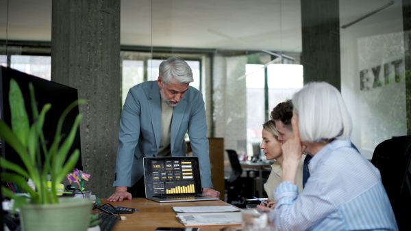 Businessman giving a presentation in a business meeting. Young colleagues and manager having casual discussion during meeting, workshop in office.